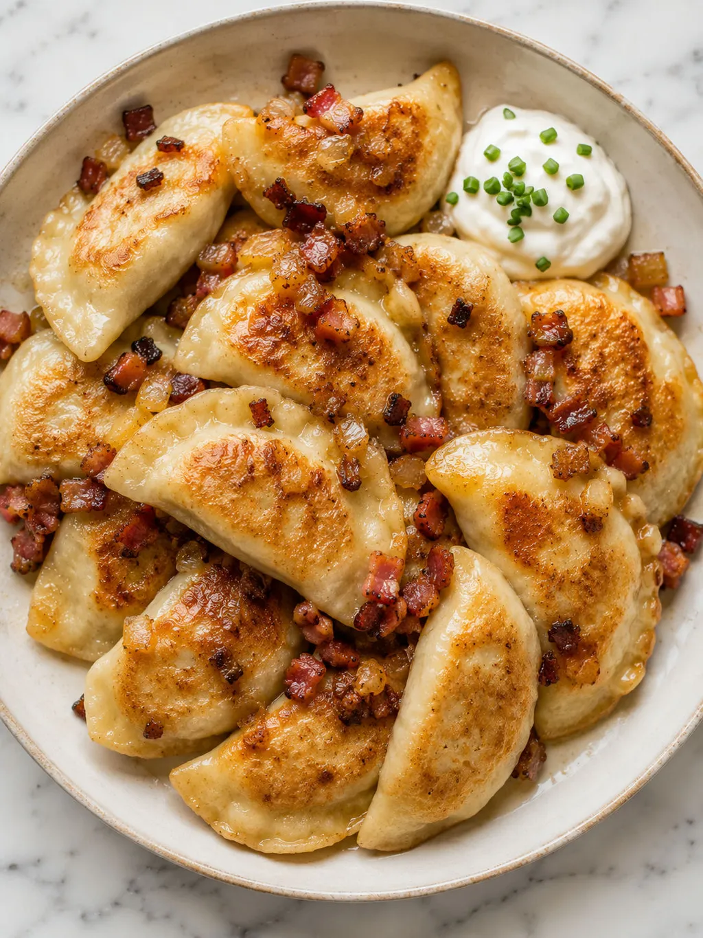 Top-down plate of golden pan-fried Polish meat pierogi with bacon and onion