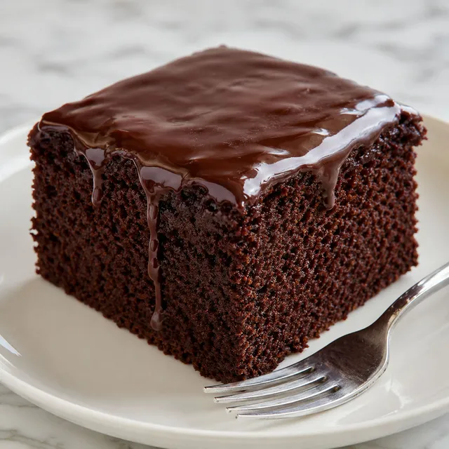 Slice of moist Polish chocolate murzynek cake with glossy cocoa glaze