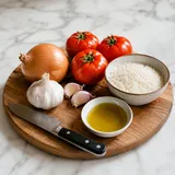 Wooden cutting board with fresh vegetables, a knife and olive oil in a home kitchen