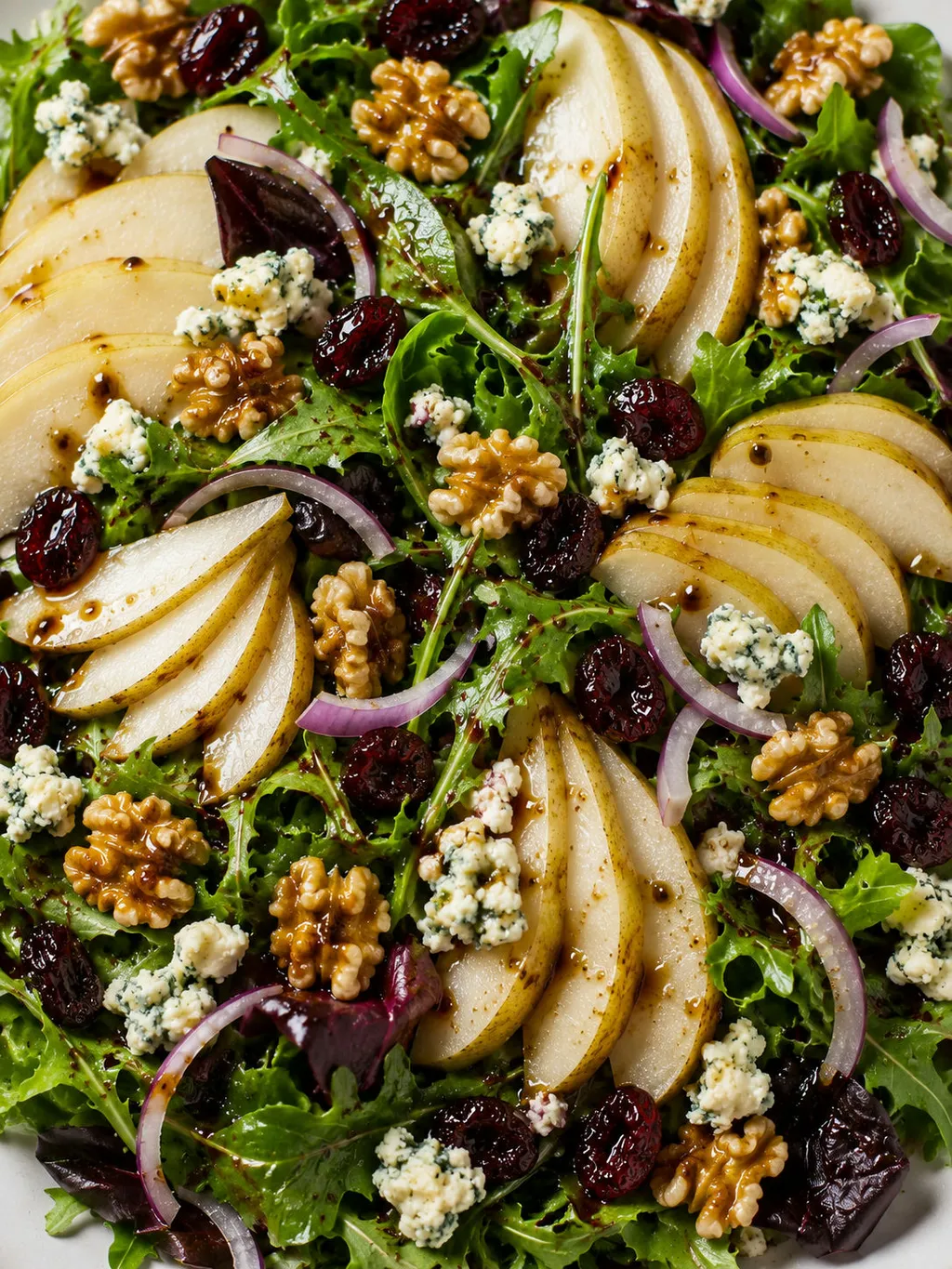 Top-down view of pear and blue cheese salad with walnuts and dried cranberries