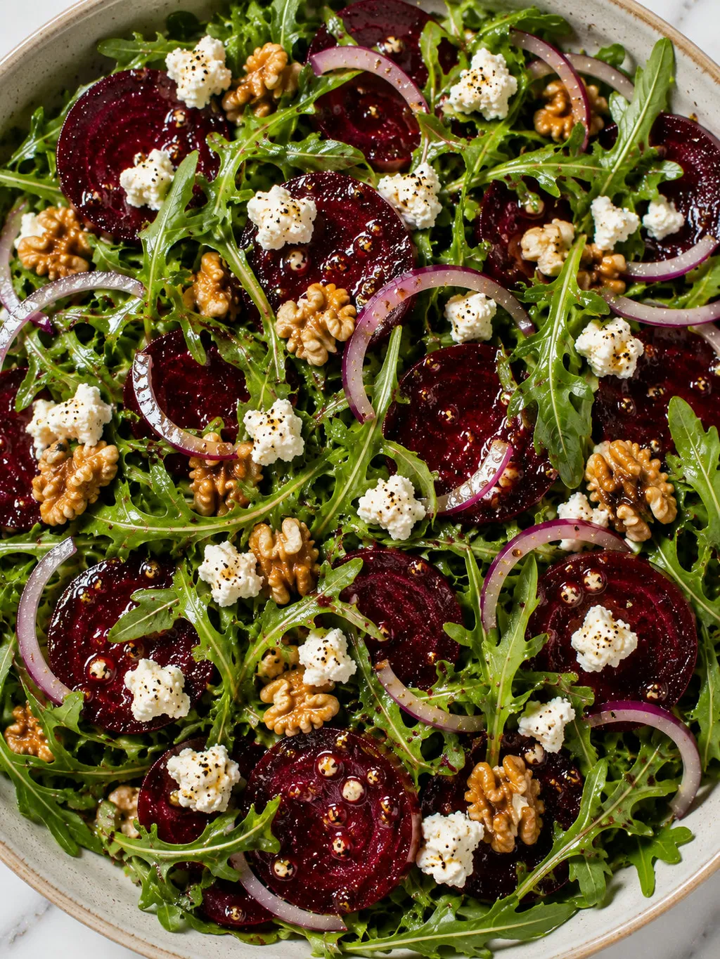 Top-down view of arugula salad with beets, feta, walnuts and red onion