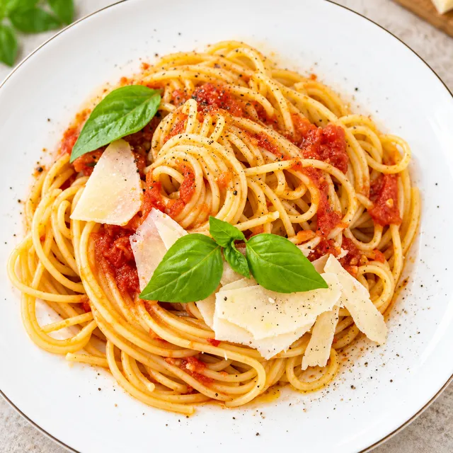 Spaghetti Napoli z sosem pomidorowym, bazylią i płatkami parmezanu